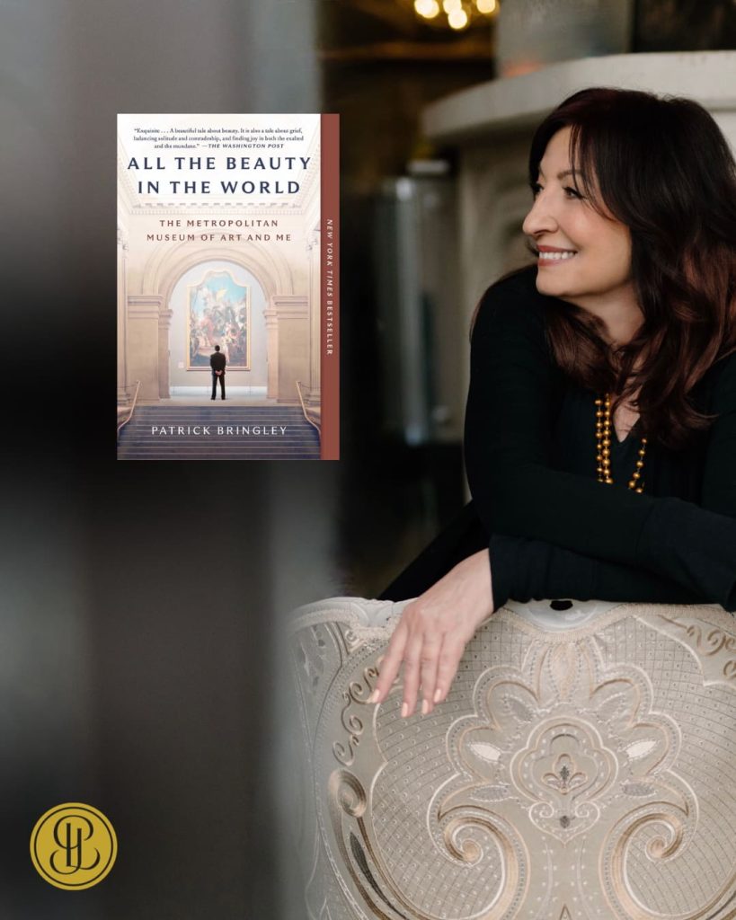 Professional woman regarding "All the Beauty in the World" book in elegant setting, representing how literature connects us to artistic sanctuary