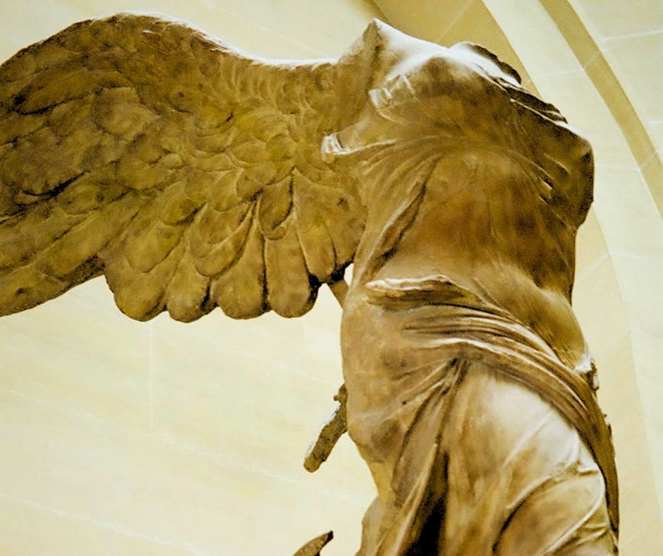 Winged Victory sculpture displaying triumphant defiance against time's ravages, embodying resilience through art as sanctuary