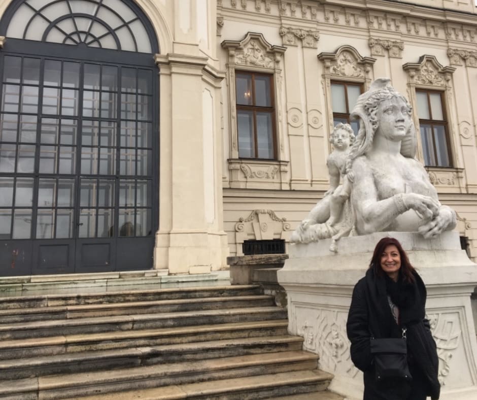 Visitor poses with classical sculptures at Belvedere Palace demonstrating the personal connection between viewers and enduring art