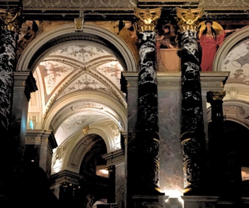 Magnificent museum gallery interior with Klimt artwork, marble columns, and ornate ceiling in institution preserving beauty across centuries